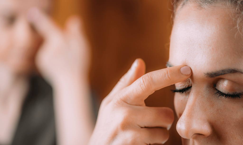 Picture of woman tapping on her eyebrow acupressure point
